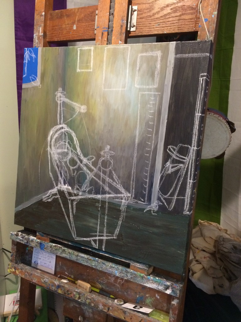 An unfinished painting on an easel. The walls of the room depicted in the painting have been painted as has some of the floor. There is a window slightly visible in the upper left corner. On the right side of the image a dark space has been painted indicating a closet. White chalk has been used to sketch a bassinet in the corner of the room and an empty cradle board tucked away in the closet. Four squares have been sketched on the wall behind the cradle indicating positioning for paintings and a growth chart. Birds have been sketched entering the room through the open window.